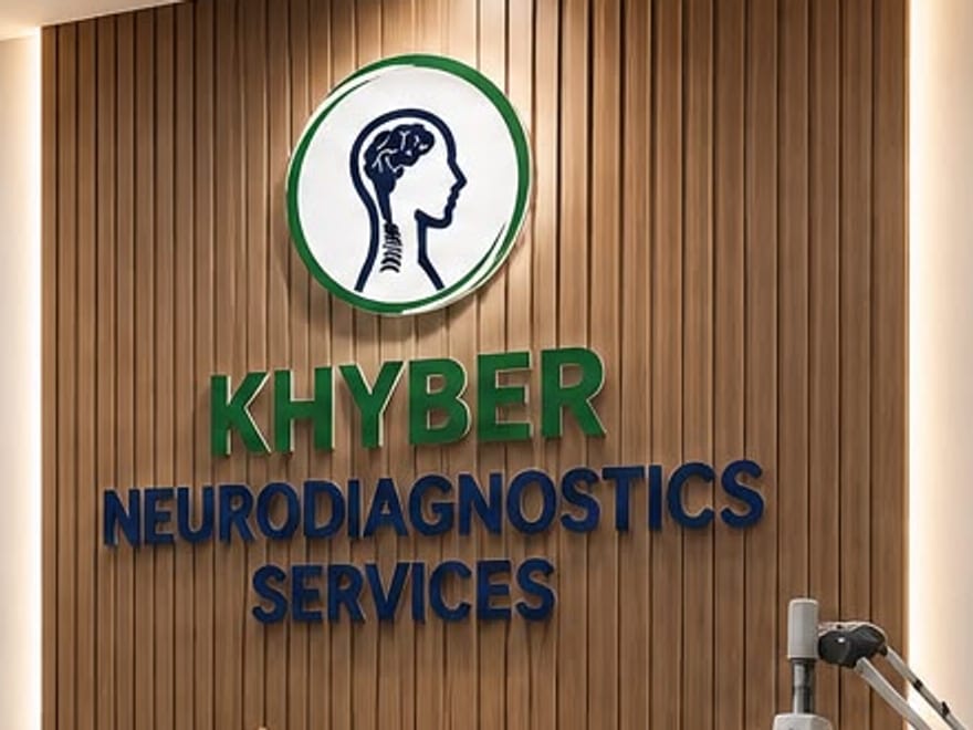 Signage inside Khyber Neurodiagnostics Services showing the clinic logo and name on a wood-panelled wall